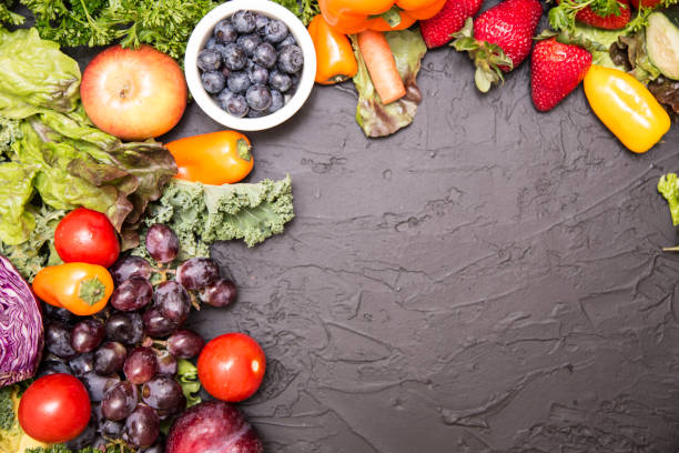 istock Healthy fruits and vegetables on black background 957806416