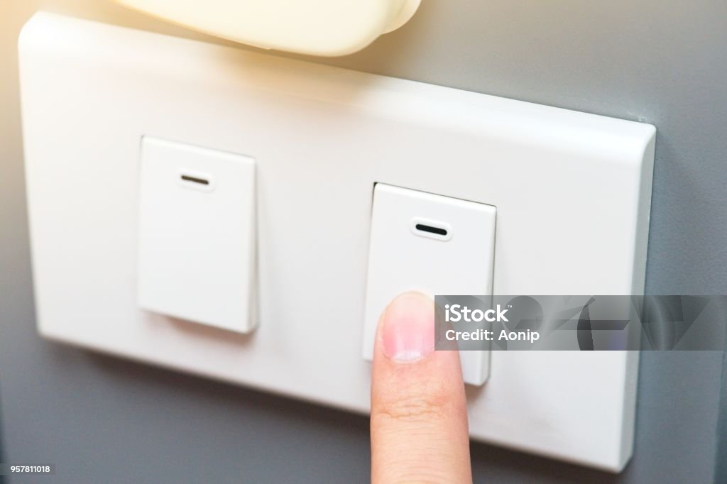 Saving energy concept, someone trying to use index finger to pressing a switch. there is yellow ray light located on top rigth of frame Saving energy concept, someone trying to use index finger to pressing a switch. there is yellow ray light located on top rigth of frame.Pointing finger Business Stock Photo