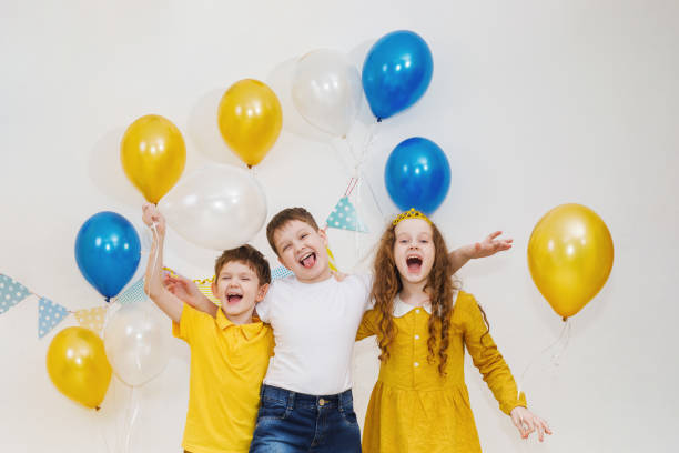 istock Laughing children on carnival party with balloons. 957811714