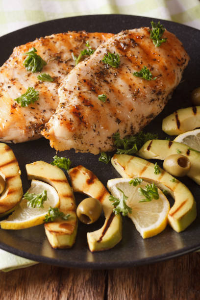 istock Diet Food: Grilled chicken breast with avocado, lemon and olive close-up. vertical 957815884