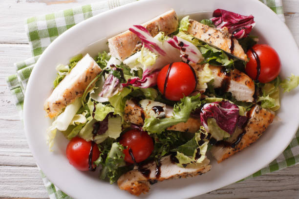 istock Fresh chicken salad, tomatoes and herbs with balsamic sauce close-up. Horizontal top view 957815932