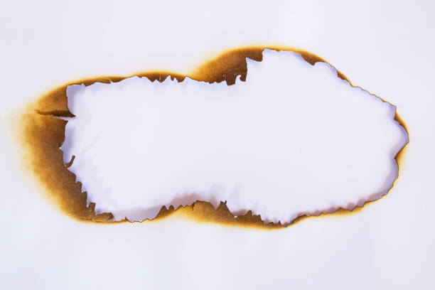 istock close up hole paper with edges burned on white background 957816932