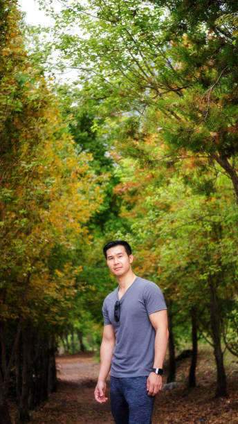 istock Asian young men standing in front of a maple tree. 957817156