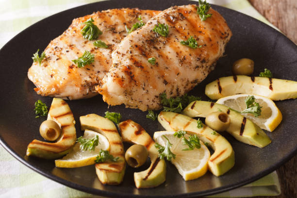istock Grilled chicken breast with avocado, lemon and olive close-up. horizontal 957817186