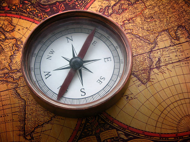 cobre bússola no mapa do mundo antigo - compass direction antique guidance imagens e fotografias de stock
