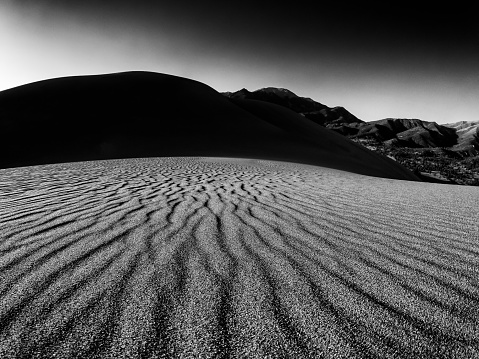 Sand Dunes at Sunset in Black and White - Black and white landscape with dramatic light and patterns on sand. Great Sand Dunes National Park, Colorado USA.