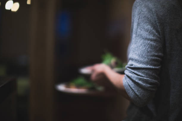 Waitress grabbing many plates in a restaurant kitchen. Caterer in Canada