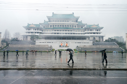 Pyongyang, 14th April 2018. People walking with umbrelas at Kim Il Sung Square while raining