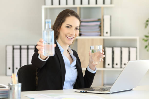 istock Office worker showing a bottle of water 957827910