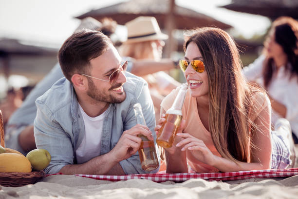 istock Group of happy young people having a picnic on the beach 957828178