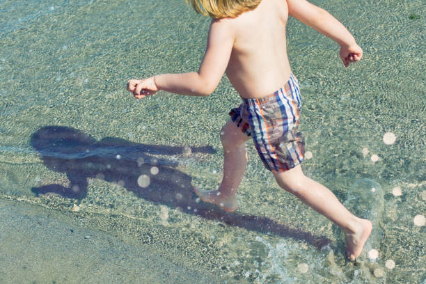 Little blonde child running on the beach