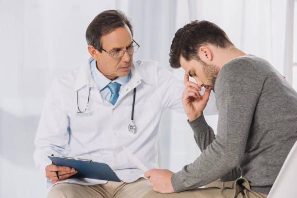 istock doctor putting hand on upset patient shoulder 957829364