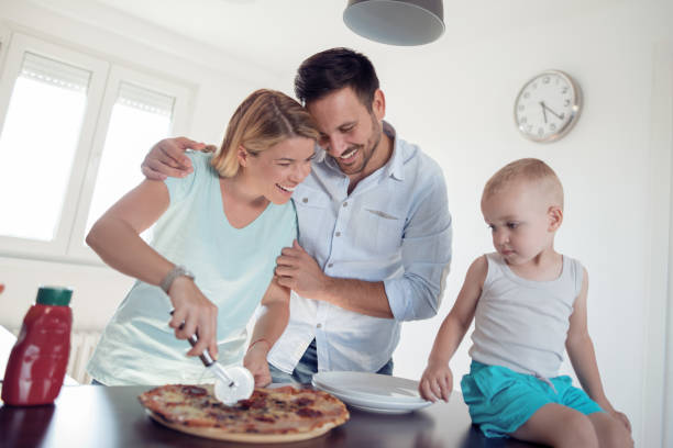 istock Family eating pizza together in kitchen 957832990