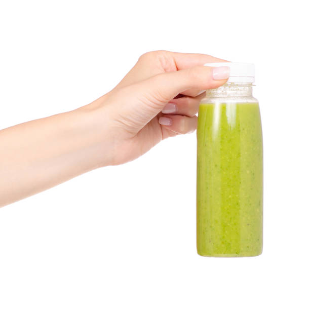 istock Bottle of smoothies green in hand 957834092