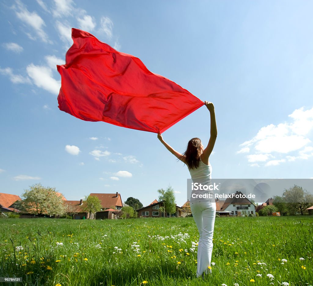 Mujer de pie en un prado de retención de viento (XL) trapo rojo - Foto de stock de 20 a 29 años libre de derechos