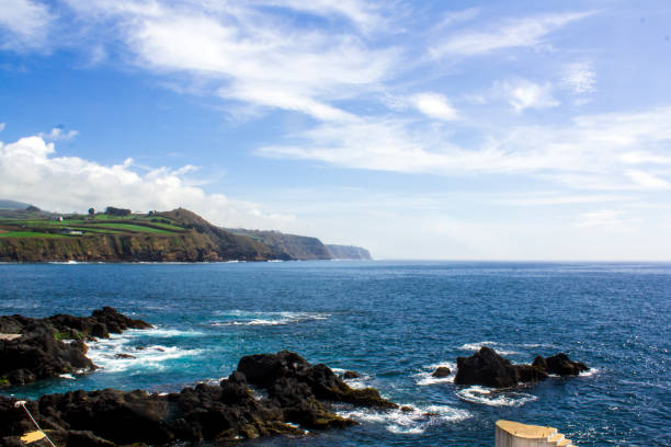 Coastline landscape with Blue Ocean and land with green fields