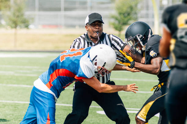Low angle view of football judge holding a yellow flag against the sky.