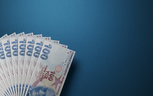 Cien billetes en liras turcas sobre fondo azul photo