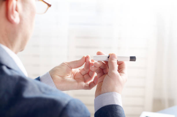 istock Middle age Man Pierce his fingertip before doing blood test with personal glucometer. Place for text 957856342