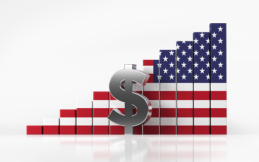 American dollar currency chart textured with American flag on white reflective surface. An American dollar sign is standing in front of the financial chart. Chart is moving up. Horizontal composition with clipping path and copy space.