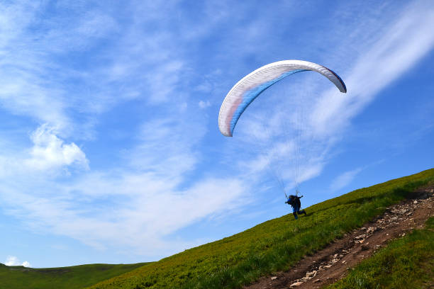 istock Skydiver on parachute in  clear sky parachuting stock image. 957859068