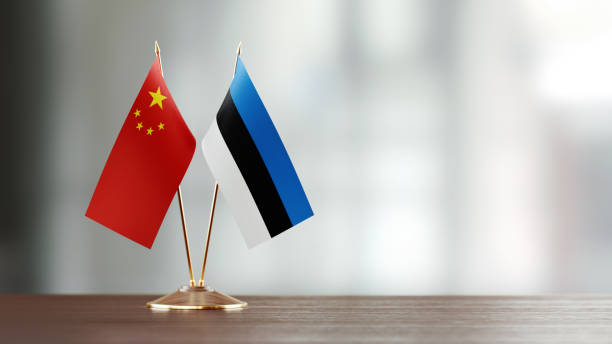 istock Chinese And Estonian Flag Pair On A Desk Over Defocused Background 957861184