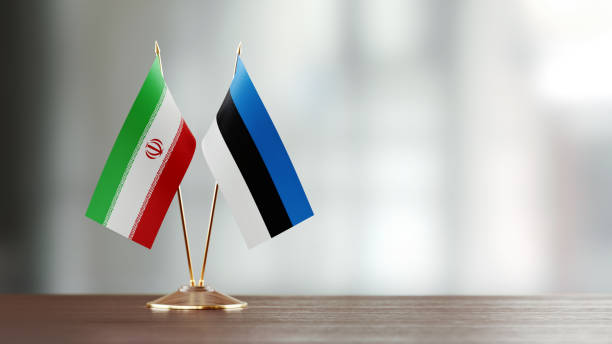 istock Iranian And Estonian Flag Pair On A Desk Over Defocused Background 957864638