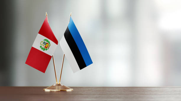 istock Peruvian And Estonian Flag Pair On A Desk Over Defocused Background 957864834