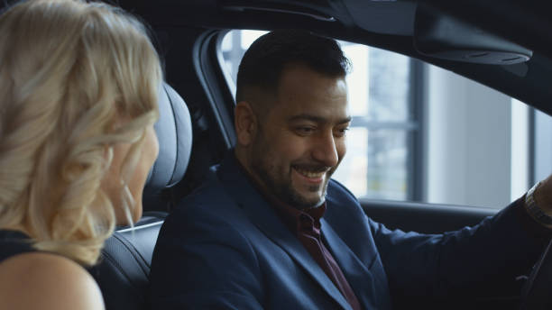 istock Successful couple testing new car in salon 957872392
