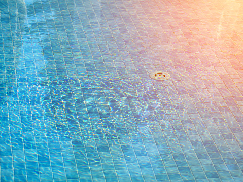 swimming pool bottom under ripple water and waves, sunlight effect