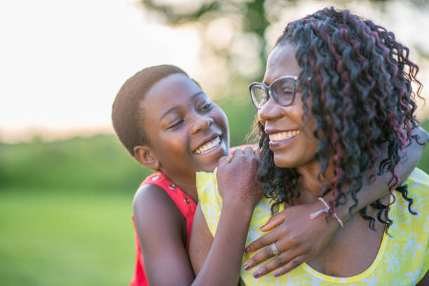 istock Mother and daughter laughing and hugging outside 957878922