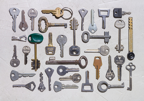 Set of various keys on rough concrete surface close-up, isolated objects, background