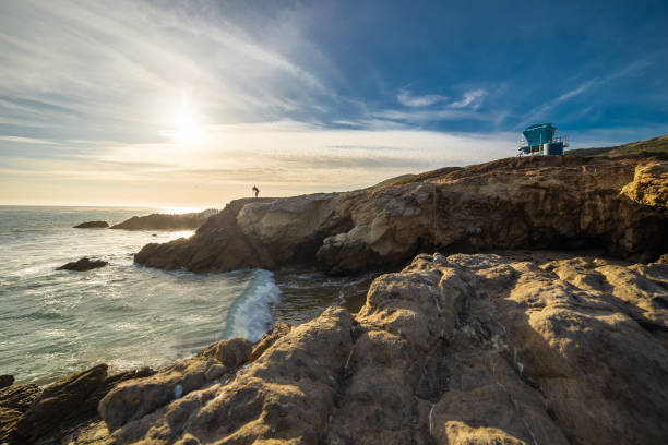 Silhouette of Photographer on Malibu Beach Coast Line Landscape Silhouette of a landscape photographer standing on the rocks along the Malibu beach coastline in California during sunset.  The image depicts an HDR image of the ocean and nature. rock sea malibu silhouette stock pictures, royalty-free photos & images