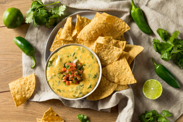 würzige hausgemachte cheesey queso-dip - tortilla chip stock-fotos und bilder