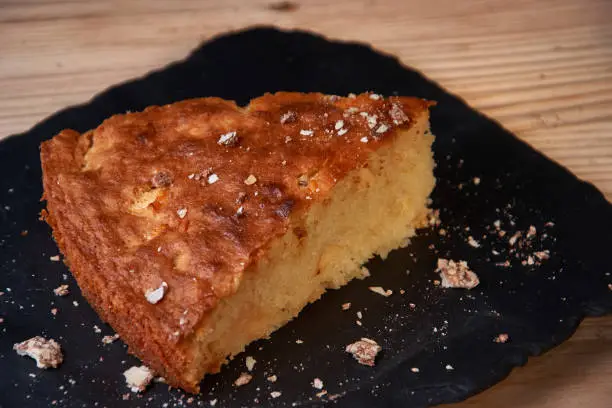 Photo of A piece of apple pie with grated chocolate near chocolate truffle candies. Selective focus and small depth of field.