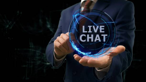 istock Businessman shows concept hologram Live chat on his hand 957904480