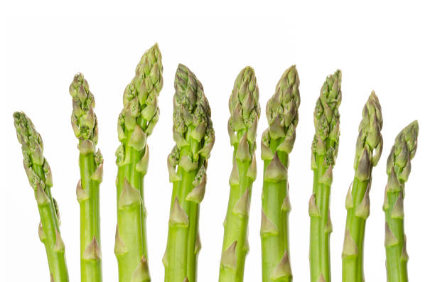 istock Fresh green asparagus tips in a row over white 957905598