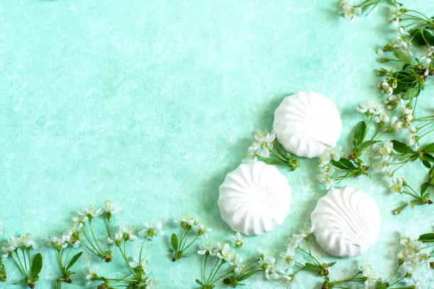 istock Delicate frame of marshmallows and cherry blossoms 957917044