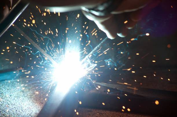 istock Worker is welding sparks table steel. 957933240