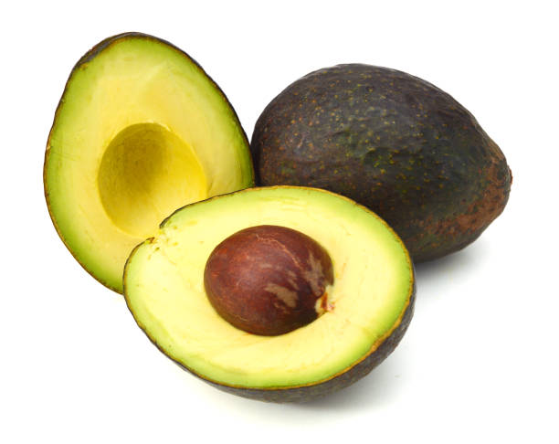 istock Whole and two half avocado isolated on white. 957951366