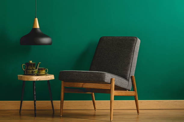 istock Upholstered chair by green wall 957956254