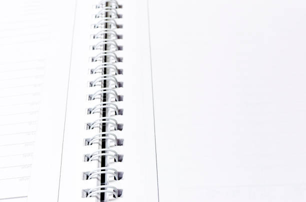 istock Close-up of a stack of spiral notebook / report / book over white background, selective focus 957956354