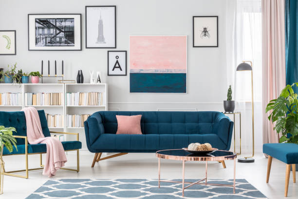 Living room with pink details Modern living room interior with blue sofa and rug, art collection and pink details metal molding stock pictures, royalty-free photos & images