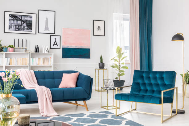 Sophisticated living room interior Blue armchair next to settee with pink pillow in sophisticated living room interior with painting fig tree photos stock pictures, royalty-free photos & images