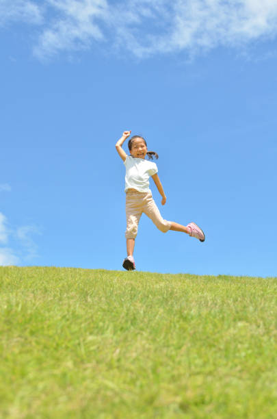 istock Girl's jumping in the blue sky 957961276