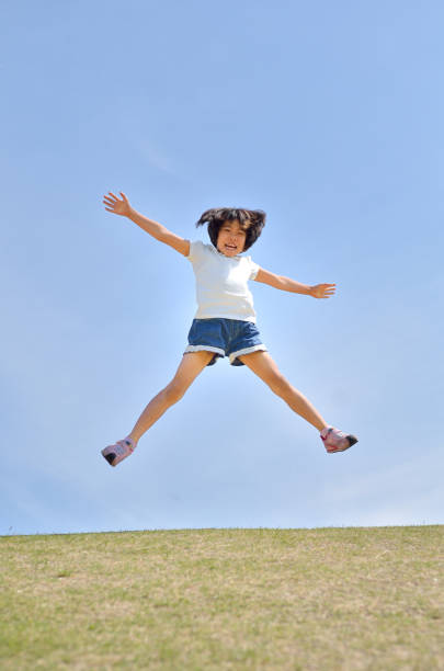 istock Girl's jumping in the blue sky 957961286