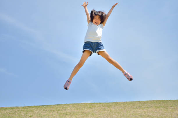 istock Girl's jumping in the blue sky 957961312
