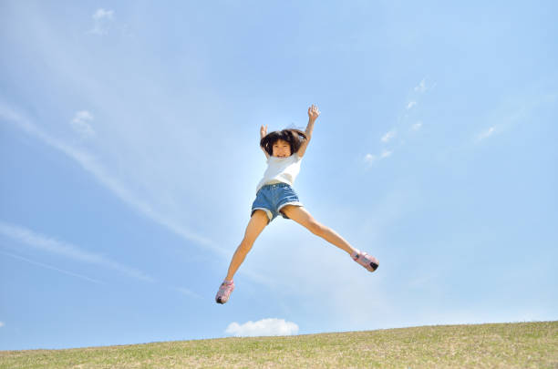 istock Girl's jumping in the blue sky 957961318