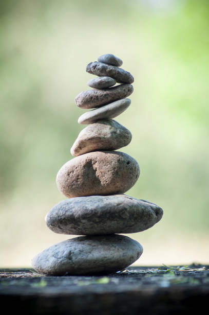 istock stones balance on wooden table on green blurred background 957972802