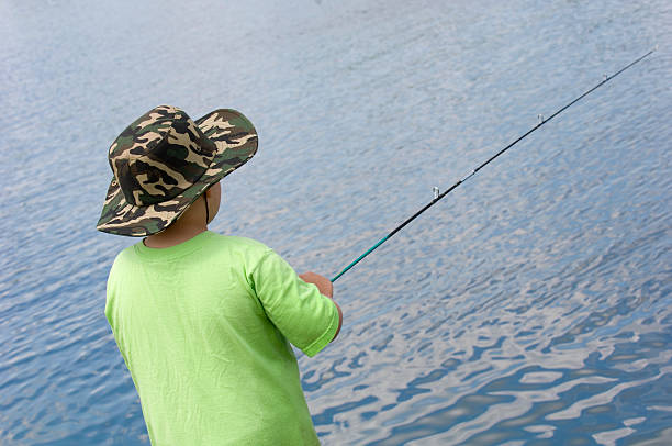 istock Boy fishing In clear, blue lake. 95797427